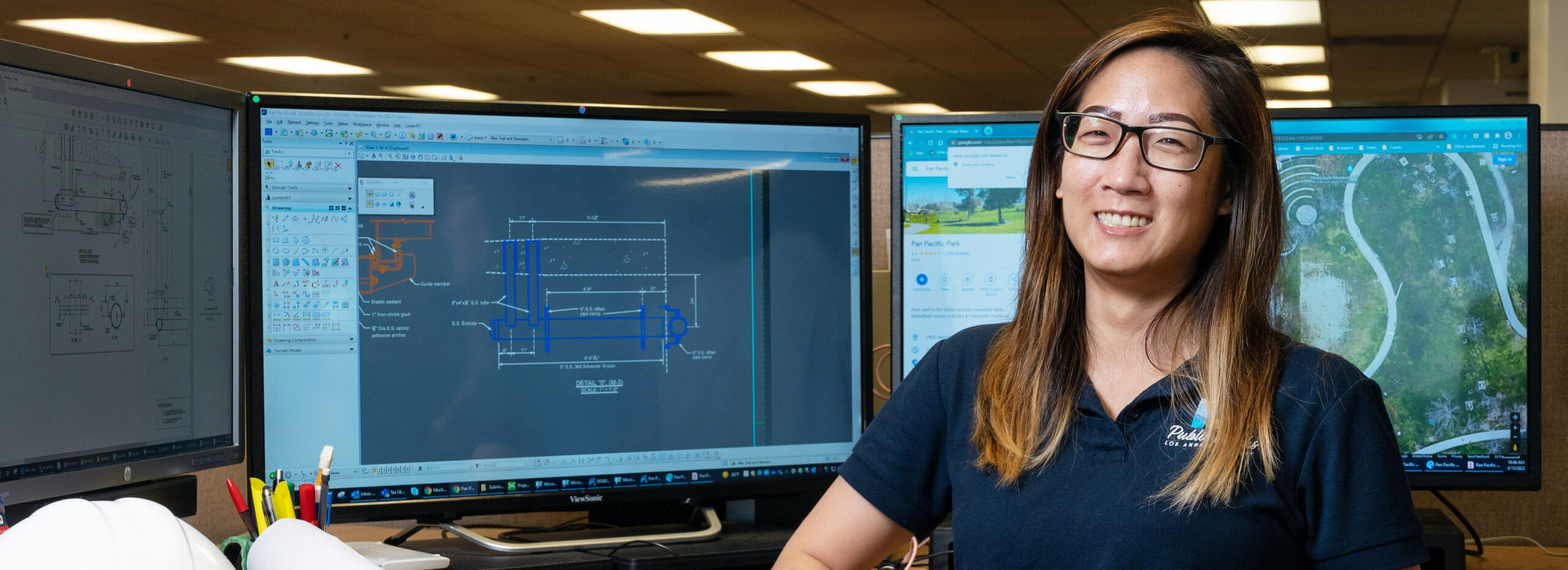 Employee sitting in front of monitors showing maps